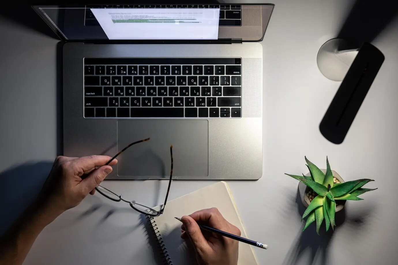 Draufsicht auf Laptop und Lampe bei nächtlicher Arbeit